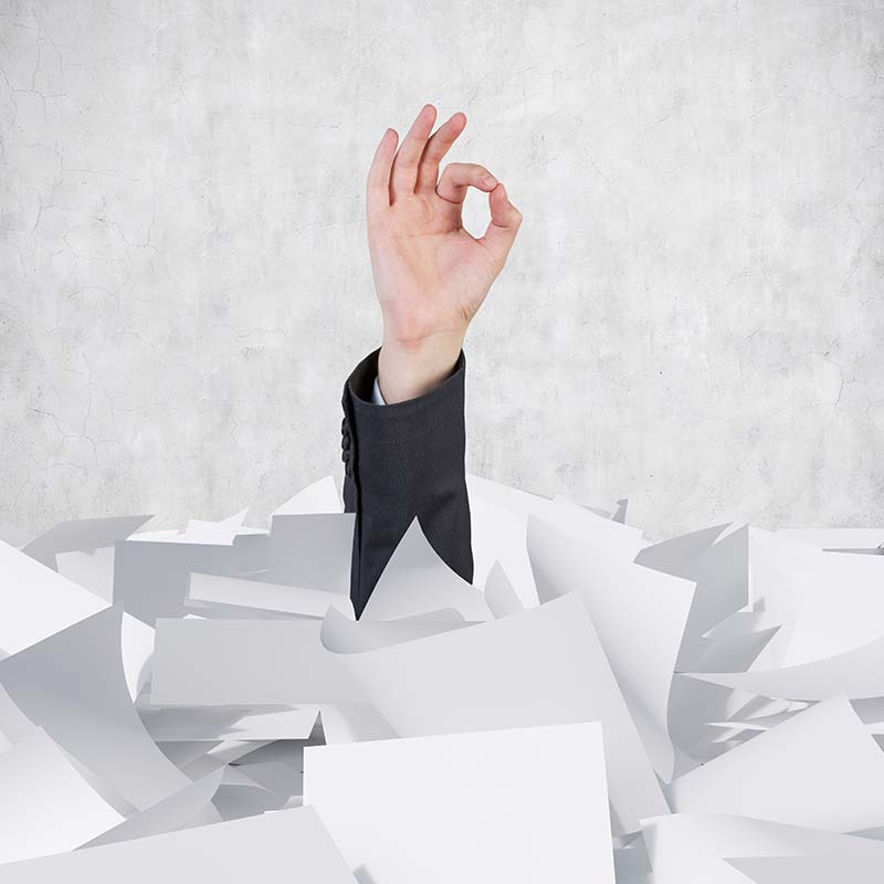 Man's arm sticking up out of a pile of papers indicating he's OK