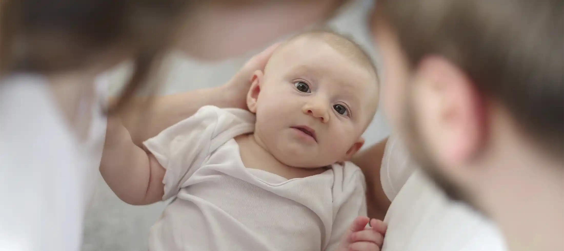 Parents looking at their new baby considering Trump Acpounts